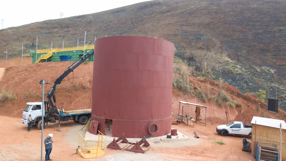 reservatório apoiado metálico sendo instalado em projeto industrial da Faz Forte, com estrutura sobre base de concreto.